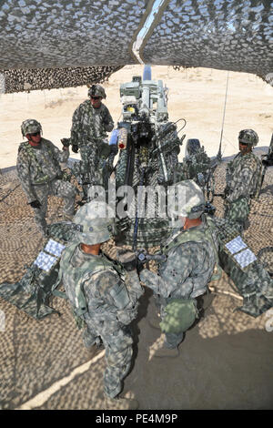 U.S. Soldiers assigned to Battery A, 2nd Battalion, 12th Field Artillery Regiment, 1st Brigade Combat Team, 4th Infantry Division, load M107, 155mm projectile ammunition for an M777 Light Towed Howitzer during calibration for Decisive Action Rotation 15-10 at the National Training Center, Fort Irwin, Calif., Sept. 10, 2015.  Decisive Action rotations create a realistic training environment that tests the capabilities of brigade combat teams preparing them to face similarly equipped opposing forces. (U.S. Army photo by Spc. Ashley Marble/Released) Stock Photo