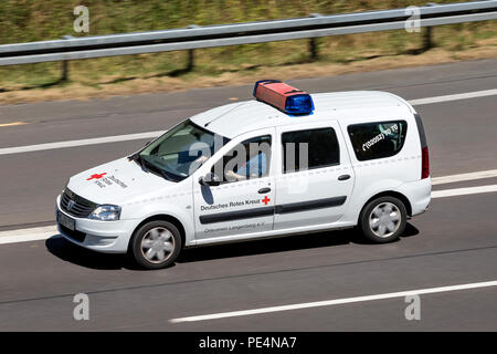 Dacia Logan of the German Red Cross on motorway. The German Red Cross, or the DRK, is the national Red Cross Society in Germany. Stock Photo