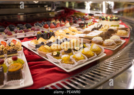 Different colorful Tasty beautiful cakes on a show-window in caf Stock Photo