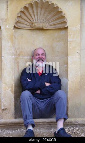 58 Year Old Man Sitting in an Architectural Recess at Ashton Court Mansion, Estate. Bristol, UK. Stock Photo