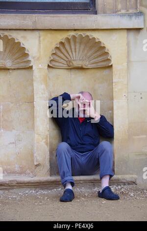 58 Year Old Man Sitting in an Architectural Recess at Ashton Court Mansion, Estate. Bristol, UK. Stock Photo