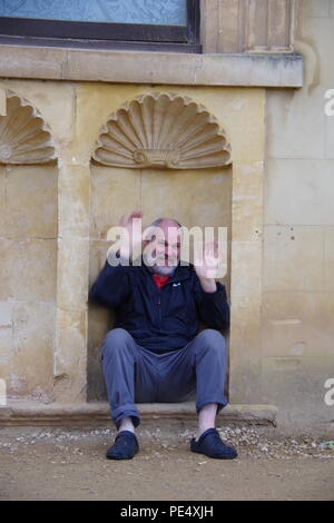 58 Year Old Man Sitting in an Architectural Recess at Ashton Court Mansion, Estate. Bristol, UK. Stock Photo