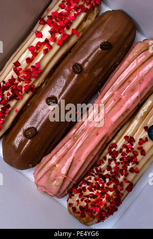 French traditional eclair, decorated with raspberry and cream Stock Photo