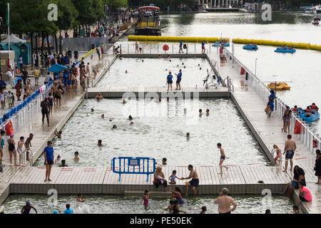 People enjoying summer in open swimming pool at the La Bassin de la Villette in Paris, France. Stock Photo