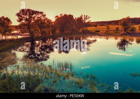 View of calm lake with beautiful reflection in the evening Stock Photo