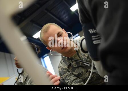 Airman 1st Class Daniel Hansen, 108th Medical Group, New Jersey Air National Guard, checks the blood pressure of a homeless veteran at the New Jersey Department of Military and Veterans Affairs Stand Down Day at the John F. Kennedy Recreation Center in Newark, N.J., on Oct. 10, 2015. The stand down day allows the veterans to get much-needed care and services from a wide array of state agencies and nonprofit organizations. Members of the 108th Medical Group have been providing care at stand down days for more than 10 years and were providing blood pressure checks as a means to have conversation Stock Photo