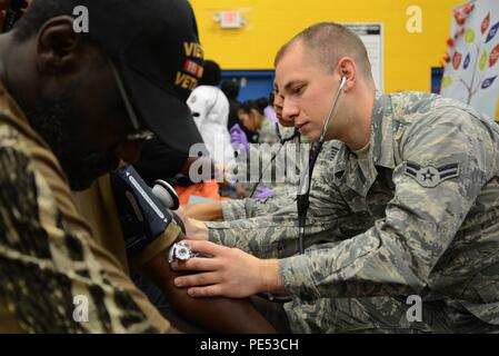 Airman 1st Class Daniel Hansen, 108th Medical Group, New Jersey Air National Guard, checks the blood pressure of a homeless veteran at the New Jersey Department of Military and Veterans Affairs Stand Down Day at the John F. Kennedy Recreation Center in Newark, N.J., on Oct. 10, 2015. The stand down day allows the veterans to get much-needed care and services from a wide array of state agencies and nonprofit organizations. Members of the 108th Medical Group have been providing care at stand down days for more than 10 years and were providing blood pressure checks as a means to have conversation Stock Photo