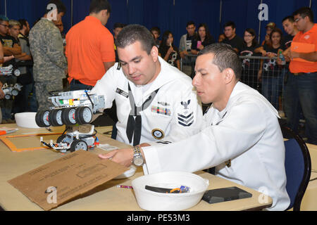 Navy recruiters from Navy Recruiting District San Antonio inspect student-built robots during Robotics Day at the 2015 Hispanic Engineering, Science and Technology Week (HESTEC) at the University of Texas-Rio Grande Valley on October 8, 2015. The event featured middle and high school students using Lego Mindstorms EV3 kits to design, build, and program autonomous robots, promoting STEM education, engineering skills, teamwork, and problem-solving while providing insight into Navy careers and technical opportunities. Stock Photo