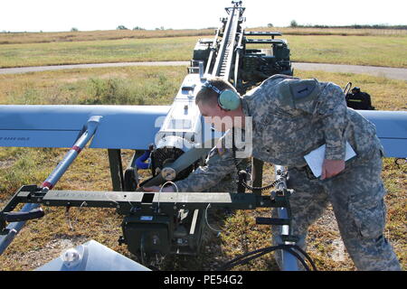 Spc. Kyle Smith, an unmanned aircraft systems repairer with Company D, 1st Engineer Battalion, 1st Armored Brigade Combat Team, 1st Infantry Division, prepares to start the RQ7-B Shadow unmanned aerial system Sept. 30 at Fort Riley, Kan. Soldiers from the 1st ABCT, 1st Inf. Div., launched the UAS along an approved air corridor and flew it back utilizing national airspace. Fort Riley was the first installation to receive permission from the FAA to fly a UAS into national airspace. Stock Photo