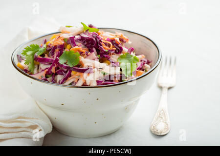 Purple cabbage and carrot salad with mayonnaise in a white bowl on a light background. Classic coleslaw. Diet vegetarian dish. Copy space Stock Photo