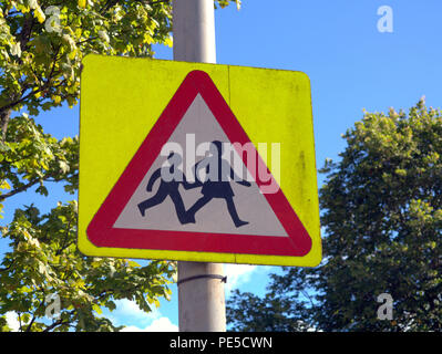 British road sign  schoolchildren children  crossing road warning sign blue sky Stock Photo