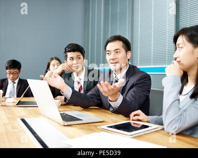 asian corporate executive and his business team meeting and negotiating with client. Stock Photo
