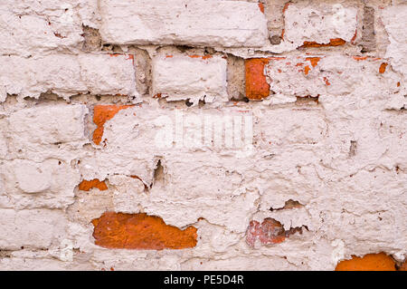 old vintage brick wall with shabby white paint background. architecture, texture. Stock Photo
