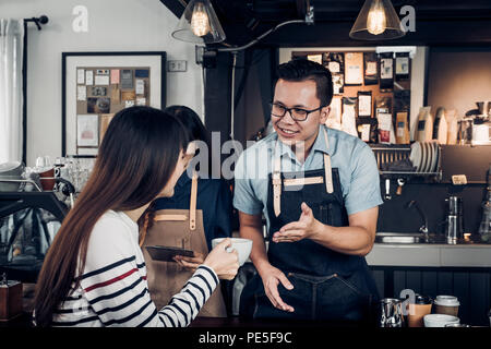 Male barista talking with customer about tasted of coffee cup with happy emotion at counter bar at cafe.coffee shop business owner concept,Service min Stock Photo