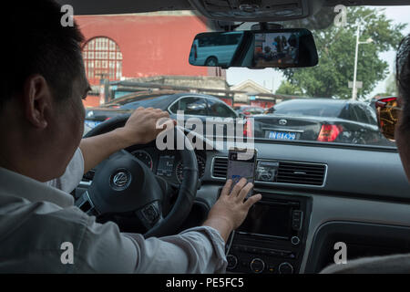 Interior of a Didi Premier car with driver Mr. Zhao in central Beijing, China. Didi Premier offers a higher-end premier mobility experience with luxur Stock Photo