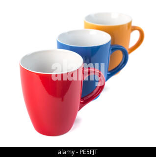 Three color ceramic cups on a white background. Stock Photo