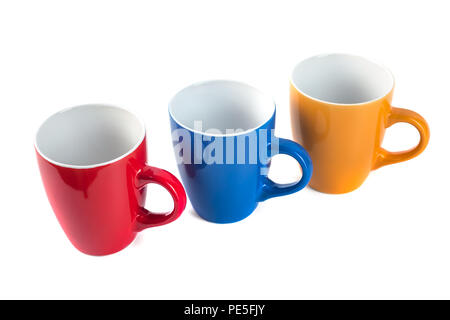 Three color ceramic cups on a white background. Stock Photo