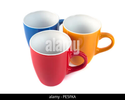 Three color ceramic cups on a white background. Stock Photo