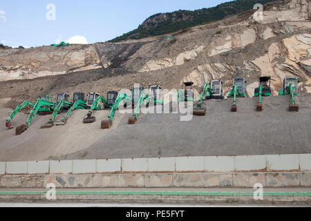 row of excavators on hill and quarry near swiss town of Sion in Wallis Stock Photo