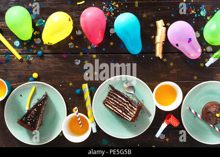 Top view children birthday table concept. Chocolate cake and decoration party on brown wooden table flat lay Stock Photo