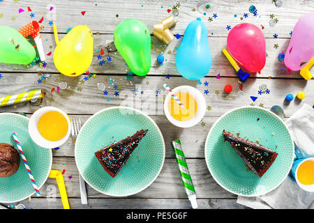 Top view children birthday table. Chocolate cake, muffins and decoration party on wooden background flat lay Stock Photo