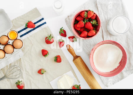Flat lay set raw ingredients for cooking strawberry pie or cake on white background with space for your text. Eggs, flour, milk, sugar, strawberry, to Stock Photo