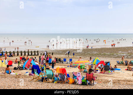 Holidaymakers, colourful deckchairs and umbrellas, East Beach at Littlehampton, a small holiday resort on the south coast in West Sussex, UK in summer Stock Photo