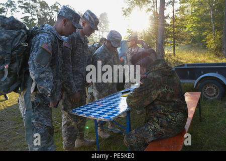 German army, Command Sgt. Major Gerhard Lindthaler, from Freihung Reserve Association, conduct an equipment inspection prior to a 12K ruck march for the U.S. Soldiers, assigned to 18th Combat Sustainment Support Battalion and 2nd Cavalry Regiment, during qualification for the German Foreign Award or Leistungsübersicht at the Grafenwoehr Training Area, Germany, Sept. 22, 2015. The soldiers must complete a series of events to earn the German Foreign Award or Leistungsübersicht (U.S. Army photo by Spc. Nathanael Mercado/Released) Stock Photo