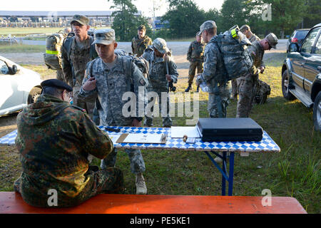 German army, Command Sgt. Major Gerhard Lindthaler, from Freihung Reserve Association, conduct an equipment inspection prior to a 12K ruck march for the U.S. Soldiers, assigned to 18th Combat Sustainment Support Battalion and 2nd Cavalry Regiment, during qualification for the German Foreign Award or Leistungsübersicht at the Grafenwoehr Training Area, Germany, Sept. 22, 2015. The soldiers must complete a series of events to earn the German Foreign Award or Leistungsübersicht. (U.S. Army photo by Spc. Nathanael Mercado/Released) Stock Photo