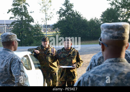 German army, Command Sgt. Major Gerhard Lindthaler, from Freihung Reserve Association, conduct a preparation briefing prior to a 12K ruck march for the U.S. Soldiers, assigned to 18th Combat Sustainment Support Battalion and 2nd Cavalry Regiment, during qualification for the German Foreign Award or Leistungsübersicht at the Grafenwoehr Training Area, Germany, Sept. 22, 2015. The soldiers must complete a series of events to earn the German Foreign Award or Leistungsübersicht.  (U.S. Army photo by Spc. Nathanael Mercado/Released) Stock Photo