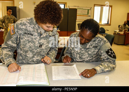 Capt. Cydnia Jackson, a senior human resource advisor for the 3rd General Support Aviation Battalion, 2nd Combat Aviation Brigade, coaches her newly enlisted Soldier step-by-step at the 3-2 GSAB office. Stock Photo