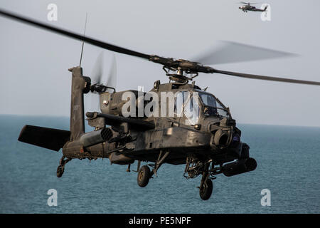 ARABIAN GULF (Sept. 28, 2015) An AH-64 Apache with the U.S. Army’s 185th Theater Aviation Brigade prepares to land aboard the amphibious assault ship USS Essex (LHD 2). These Soldiers practiced landing and departing from the Essex in order to familiarize themselves with flight operations aboard a ship. The 15th Marine Expeditionary Unit, embarked aboard the ships of the Essex Amphibious Ready Group, is deployed to maintain regional security in the U.S. 5th Fleet area of operations. (U.S. Marine Corps photo by Cpl. Anna Albrecht/Released) Stock Photo