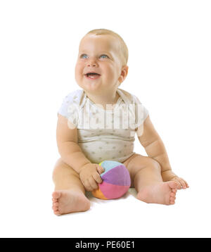 Adorable baby boy siting with colorful ball between his legs, looking up and laughing. Isolated on white background. Stock Photo