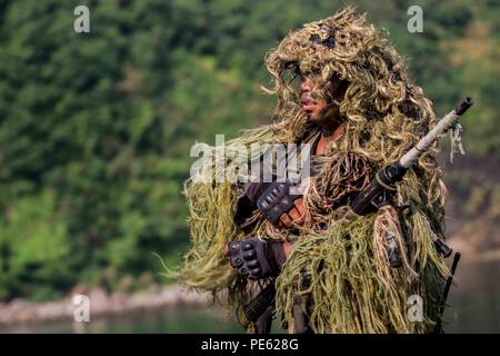 Philippine Marine Corps Cpl. Rosewel L. Bedaña, scout sniper with 64th Force Reconnaissance Company, Marine Special Operation Forces Group, adjusts his gear during an amphibious raid at Ternate, Philippines, as a part of Amphibious Landing Exercise 2015 (PHIBLEX 15), Oct. 8. PHIBLEX 15 is an annual bilateral training exercise conducted with the Armed Forces of the Philippines in order to strengthen our interoperability and working relationships across a wide range of military operations from disaster relief to complex expeditionary operations. (U.S. Marine Corps photo by Lance Cpl. Juan Bustos Stock Photo