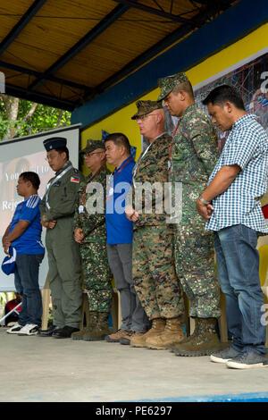 Philippine service members, school staff and U.S. Marine Corps Col. Charles Western, chief of staff, 3rd Marine Expeditionary Brigade, bow their heads for the invocation during a ribbon cutting ceremony for the humanitarian civic assistance project at Concepcion Elementary School in Palawan, Philippines, during Amphibious Landing Exercise 2015 (PHIBLEX 15), Oct. 8. PHIBLEX 15 is an annual bilateral training exercise conducted with the Armed Forces of the Philippines in order to strengthen our interoperability and working relationships across a wide range of military operations from disaster re Stock Photo