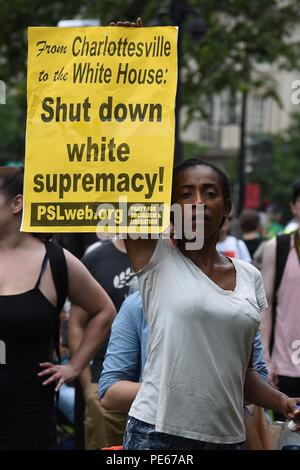 (180812) -- WASHINGTON, Aug. 12, 2018 (Xinhua) -- An anti-protester holds a placard in front of the white supremacist-led rally near the White House, in Washington, DC, the United States, on Aug. 12, 2018. Thousands of anti-protesters gathered in several locations in central Washington Sunday afternoon, hours before a controversial right supremacist rally is scheduled. The protesters gathered in the country's capital to mark the one-year anniversary of the deadly Charlottesville protest, during which a white supremacist killed a female anti-protester, sparking nationwide furor. (Xinhua/Yang C Stock Photo