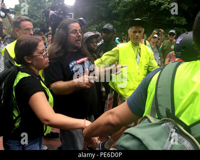 12 August 2018, USA, District of Columbia, Washington: During a demonstration against an extreme right-wing march in front of the White House on the anniversary of the deadly protests in Charlottesville, a Trump supporter is safeguarded by security forces and escorted from the crowd. On the anniversary of the deadly protests in Charlottesville, thousands of demonstrators in Washington opposed a very small number of right-wing extremists. Only a few dozen people came to the parade 'United the Right 2' in front of the White House in the US capital on Sunday 12 August 2018, as reported by US medi Stock Photo