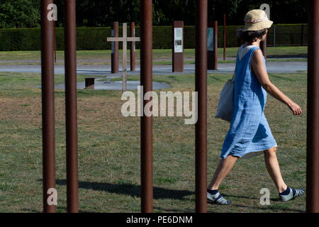 Berlin, Germany. 09th Aug, 2018. A woman walks along Bernauer Strasse behind metal bars, which serve as a symbol of the former course of the Berlin Wall. On 13 August 1961, the construction of the Wall began, which divided Berlin for more than 28 years. Credit: Lisa Ducret/dpa/Alamy Live News Stock Photo