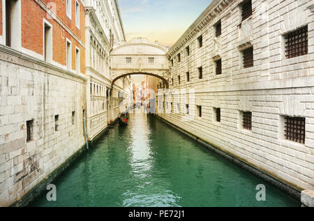 Venice, Italy, Jun 8, 2018: View of bridge of sighs with gondoliers carrying tourists in their gondolas in Venice, italy at sunset Stock Photo