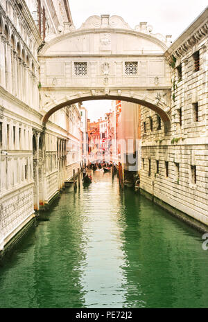 Venice, Italy, Jun 8, 2018: View of bridge of sighs with gondoliers carrying tourists in their gondolas in Venice, italy at sunset Stock Photo