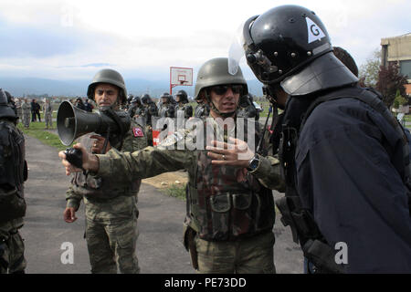 Turkish Army Capt. Hanifi Savas, commander for the Turkish Maneuver Company supporting the NATO Kosovo Force mission and assigned to Multinational Battle Group-East, speaks to a member of Kosovo Police crowd and riot control team leader during Operation Stonewall, Oct. 16, 2015, outside the Bill Clinton Sports Center in Ferizaj, Kosovo. Operation Stonewall was a combined emergency response training event, which incorporated a crowd riot control situation, held by the Kosovo Police and KFOR soldiers assigned to MNBG-E. The exercise incorporated more than 350 personnel from across several agenci Stock Photo