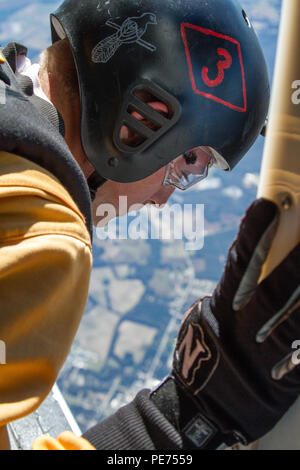 Golden Knights candidate Sgt. Daniel Gerlach looks out of a UV-18 Twin Otter aircraft over Laurinburg, N.C., to find the correct spot for his next jump to practice a skydiving maneuver called diamond tracking during tryouts to become a member of the U.S Army Parachute Team the Golden Knights. (U.S. Army photo by Staff Sgt. David Meyer, 49th Public Affairs Detachment/Released) Stock Photo