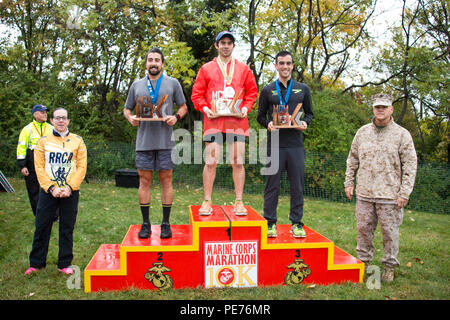 Commandant of the Marine Corps, Gen. Robert B. Neller, poses with the top three men finishers of the Marine Corps Marathon 10k at Arlington, Va., Oct. 25, 2015. Over 30,000 runners participated in the 40th annual Marine Corps Marathon. (U.S. Marine Corps photo by Sgt. Gabriela Garcia/Released) Stock Photo