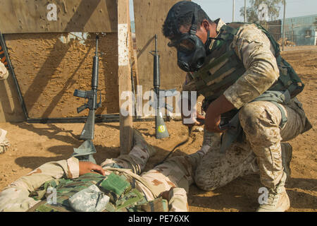 An Iraqi soldier assigned to the 71st Iraqi Army Brigade performs first aid while wearing a protective mask during a patrol scenario at Camp Taji, Iraq, Oct. 15, 2015. Iraqi soldiers were issued protective masks in order protect themselves from possible biochemical attacks. The training received at the Camp Taji building partner capacity site will assist them in assaults against the Islamic State of Iraq and the Levant. (U.S. Army photo by Spc. William Marlow/Released) Stock Photo