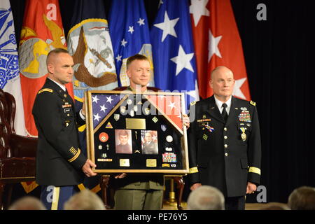 U.S. Army Col. James Becker and U.S. Marines Corps Col. Philippe D. Rogers, both with U.S. Delegation NATO, present a shadow box to Lt. Gen. David R. Hogg during his retirement ceremony at NATO Headquarters' auditorium in Brussels, Belgium, Sept. 15, 2015. (U.S. Army photo by Visual Information Specialist Pascal Demeuldre/Released) Stock Photo
