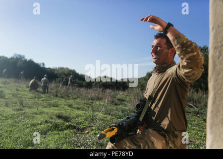 A Royal Marine with 45 Commando gives hand-and-arm signals to other Marines while on patrol during Trident Juncture 15, Oct. 23, 2015. Trident Juncture is one of many exercises ensuring that NATO is ready to deal with any emerging crisis from any direction, and that the Alliance is able to work effectively with partner nations. (U.S. Marine Corps photo by Cpl. Kaitlyn V. Klein/Released) Stock Photo