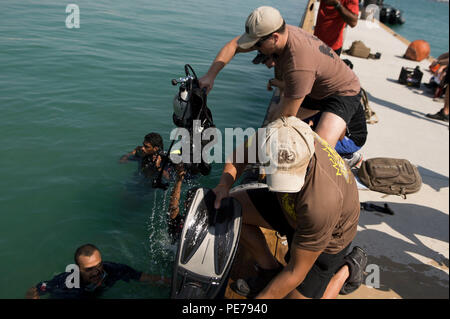 On October 27, 2015, Navy explosive ordnance disposal technicians from CTG 56.1 assisted Bahrain Coast Guard divers exiting the water during a scuba diving subject matter expert exchange at Naval Support Activity Bahrain. CTG 56.1 provides mine countermeasures, EOD operations, salvage diving, and force protection support across the U.S. 5th Fleet operational area, enhancing interoperability, safety, and professional skill exchange between U.S. and allied forces. Stock Photo
