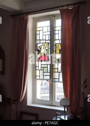 Printed and hand coloured stained glass window panels 1900's hanging in a French house window as a decoration Stock Photo