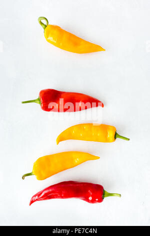 Yellow and Red Romano Peppers on Light Gray Textured and Patterned background with copy space. Stock Photo