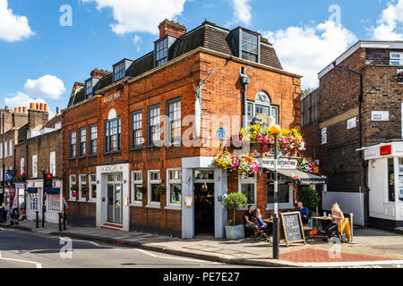 Customers drinking outside the historic Angel Inn in Highgate Village, London, UK during a heatwave Stock Photo